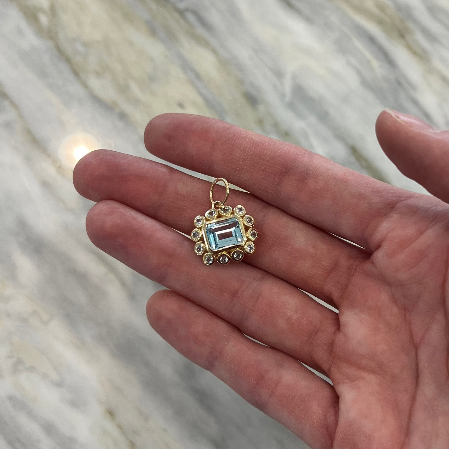 East West Emerald Cut Blue Topaz Pendant with Bezeled Blue Topaz Halo